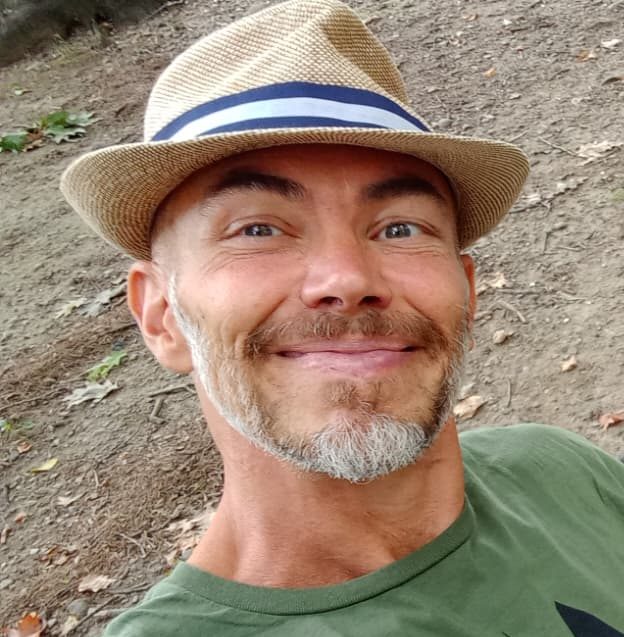 Daniele Guainazzi sorride con un cappello di paglia
